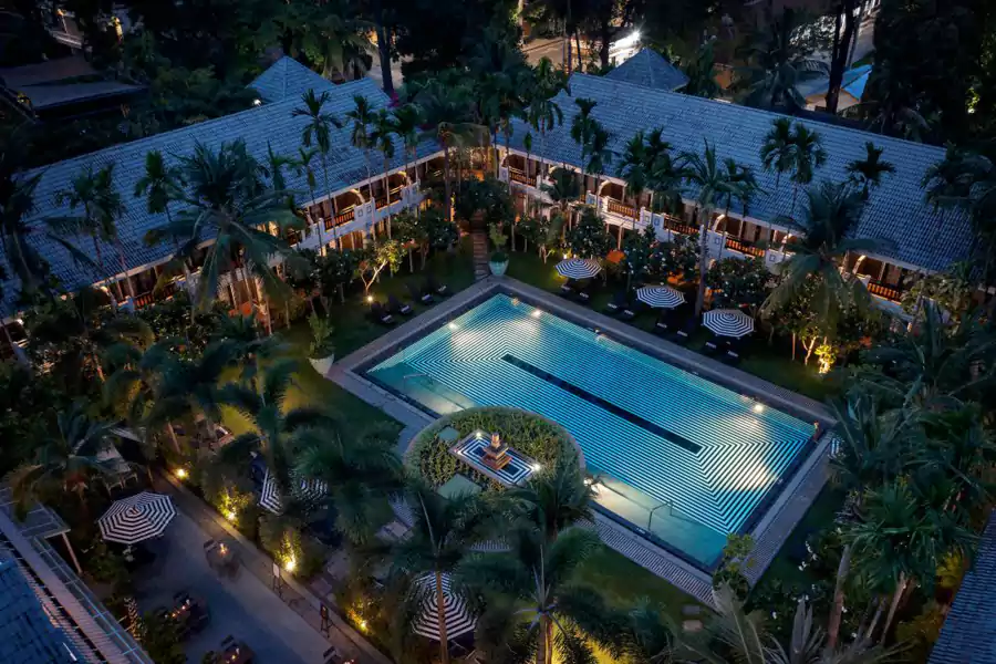 郁郁葱葱的热带绿植缠绕着建筑，黑白条纹与格子元素勾勒出鲜明辨识度