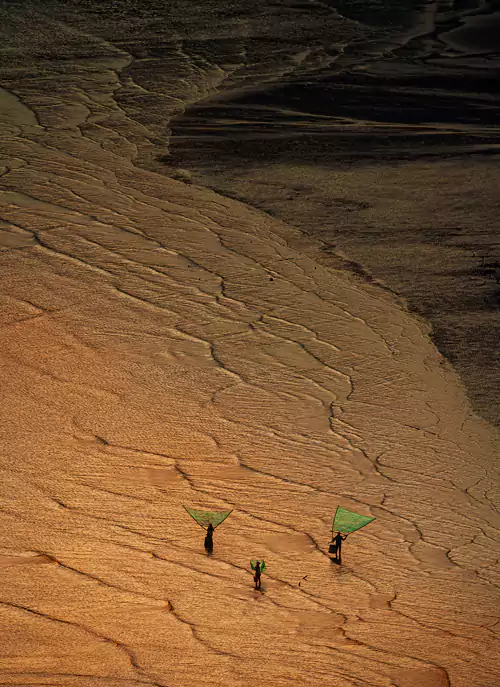 夏日的阳光洒在滩涂上,潮水退去后,留下的水痕像树枝般交错 夏日的阳光洒在滩涂上,潮水退去后,留下的水痕像树枝般交错
