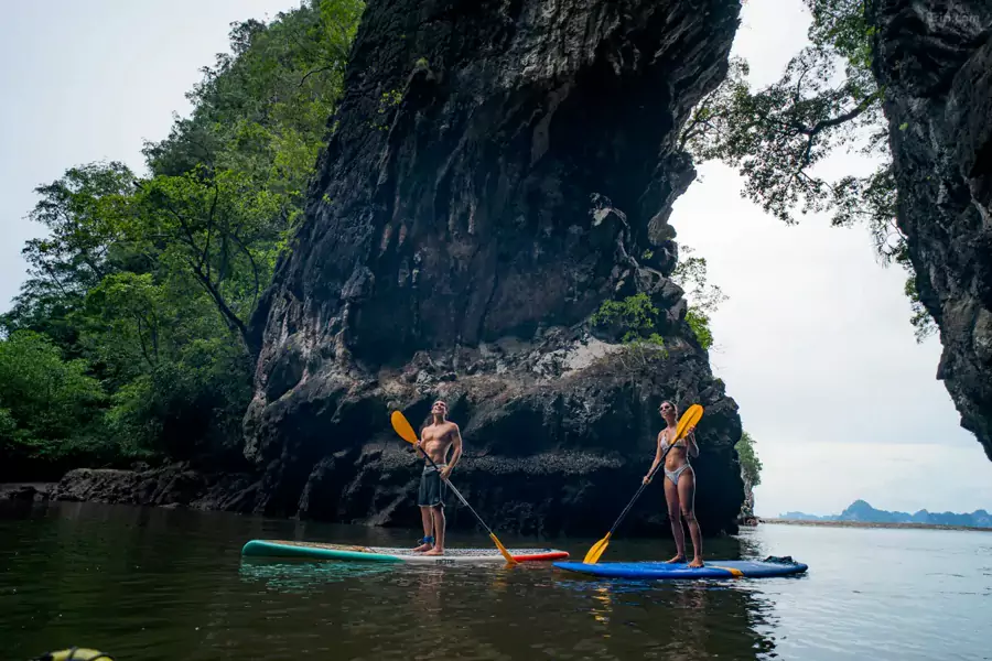 踩着桨板在平静的海湾里滑行