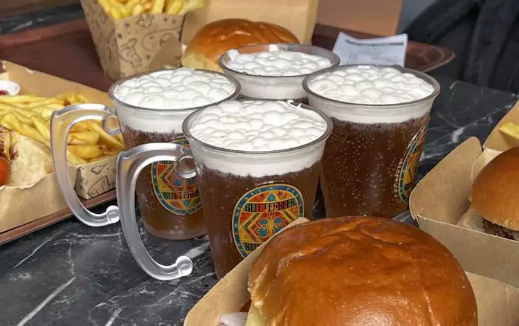 琥珀色的液体装在印有霍格沃茨标志的杯子里 琥珀色的液体装在印有霍格沃茨标志的杯子里