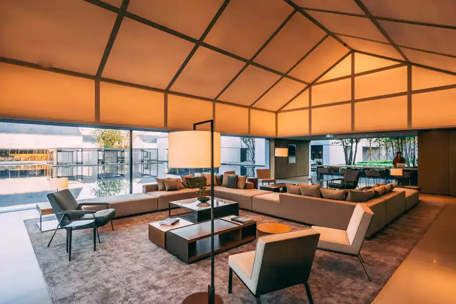 酒店公区沿中央人工湖铺展，大堂的整面落地窗将湖光山色引入室内